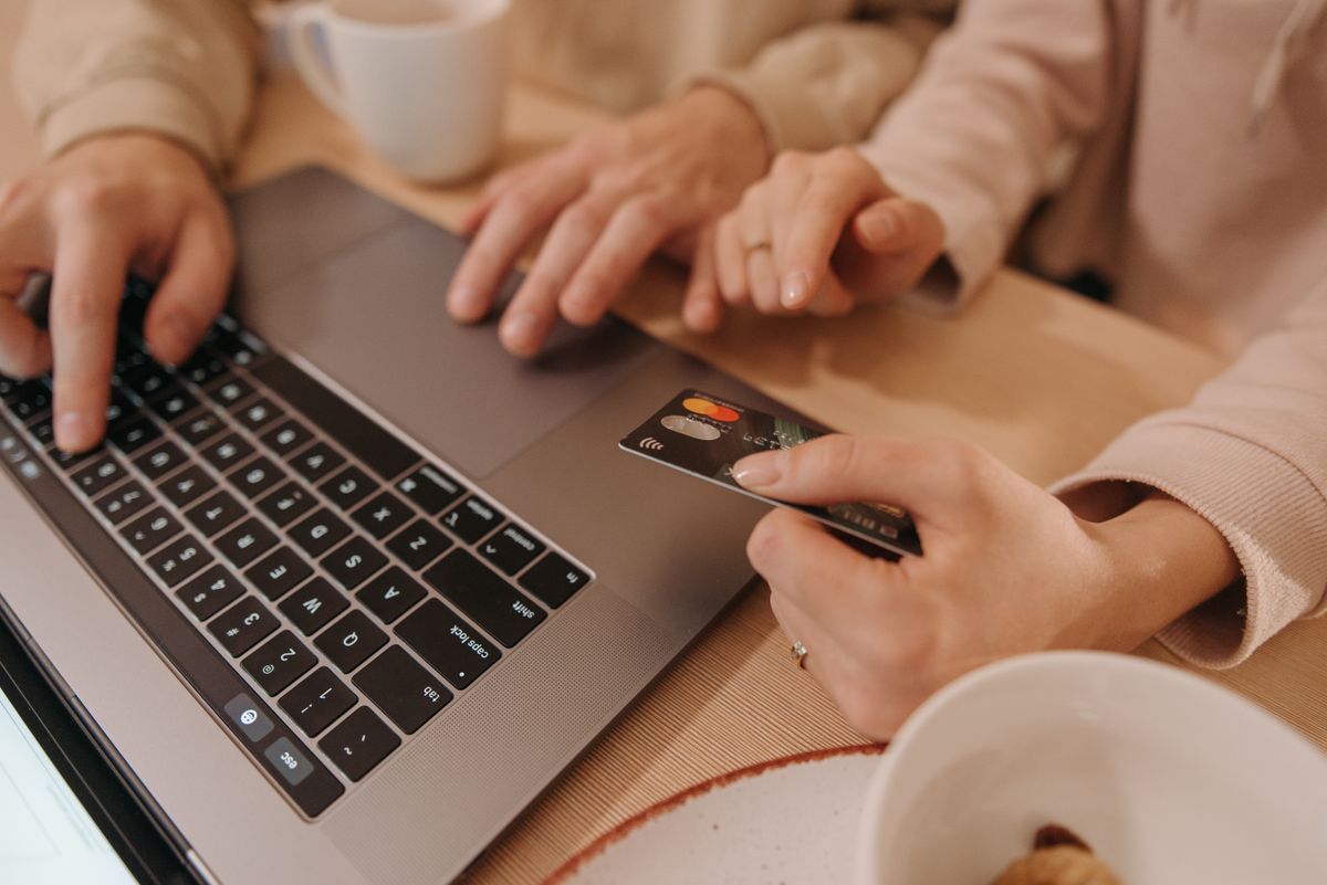 Two people reviewing a laptop and a card together